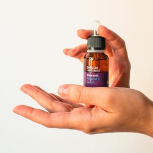 Close-up image of hands holding a cosmetics serum bottle, perfect for skincare themes.